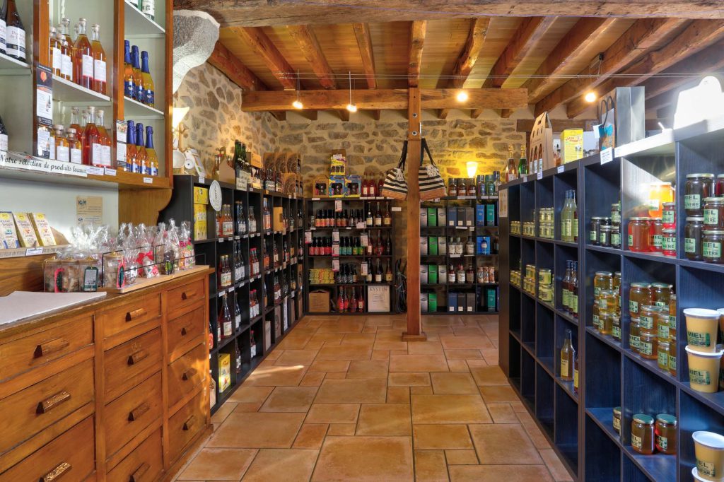 Intérieur boutique Le P'tit Fausset avec comptoir en bois, cidres et rayon de miels