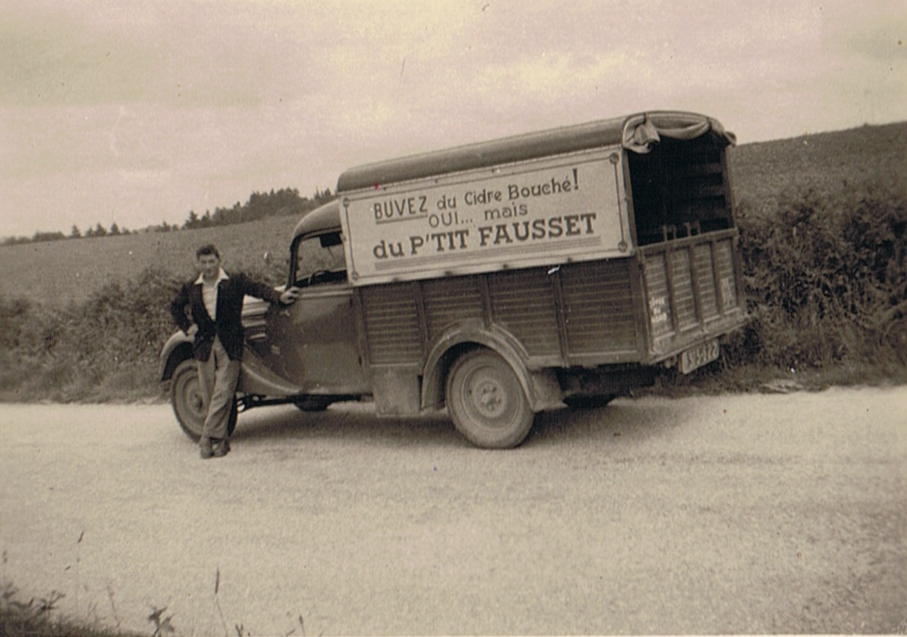 Camion vintage de livraison avec publicité « Buvez du Cidre Bouché du P'tit Fausset » et Paul au volant