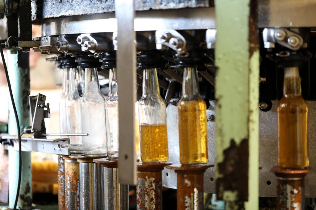 Machine rotative remplissant des bouteilles de cidre ambré sur la ligne de production